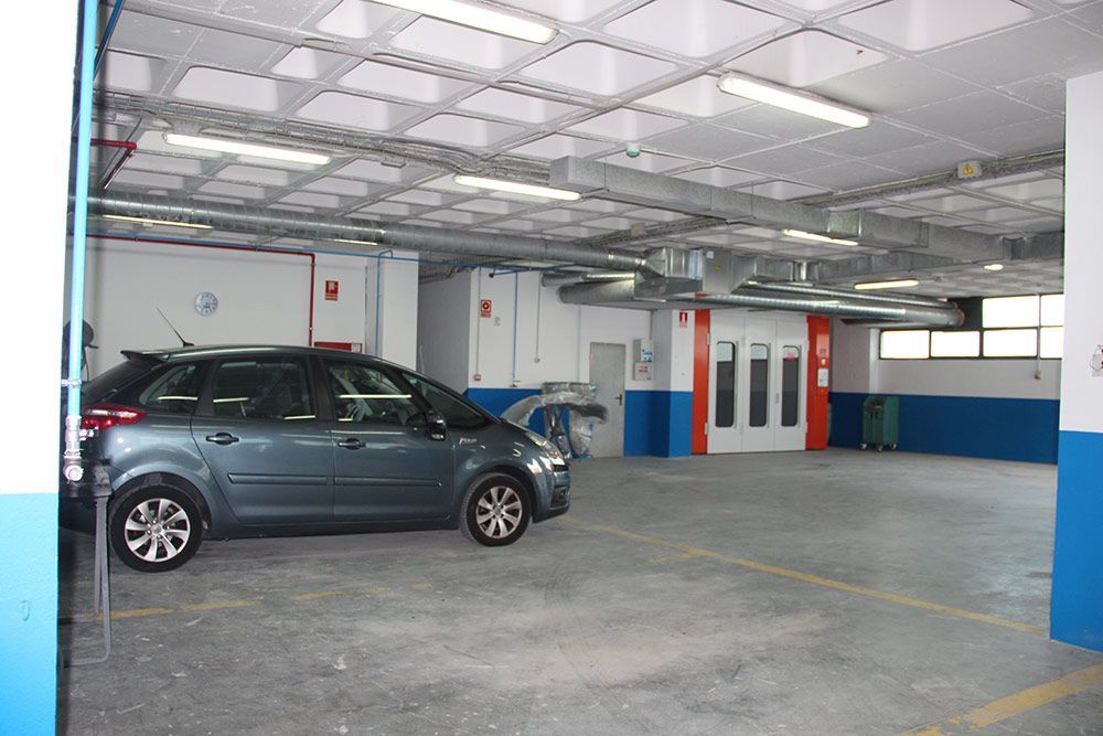 Interior del taller  con coche y cabina de pintado